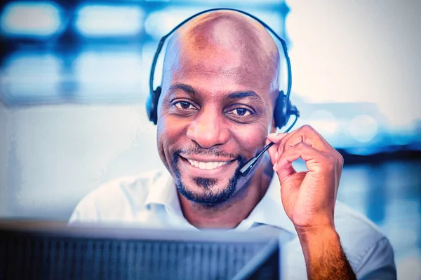 Portrait of a man working on computer with headset in office