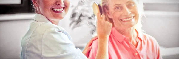 Женщина Медсестра Расчесывает Волосы Пожилой Женщины Дома — стоковое фото