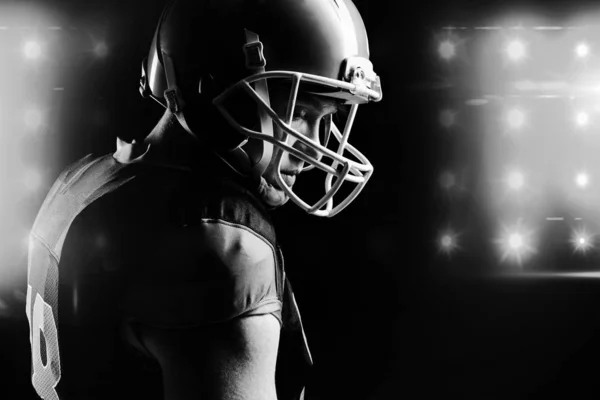 Doordachte American Football Speler Helm Staande Tegen Zwarte Achtergrond — Stockfoto