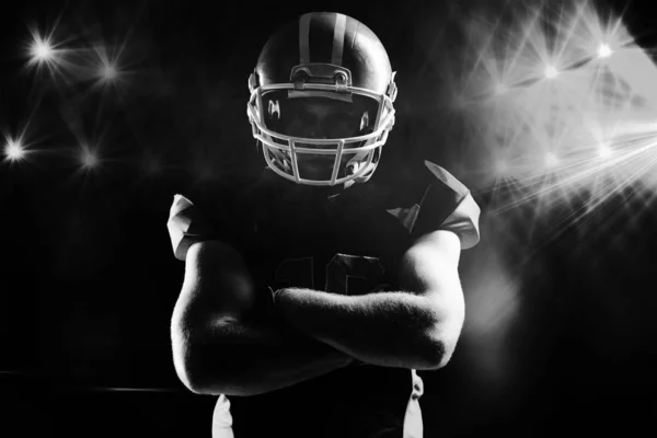 黒の背景に腕をヘルメット状態でアメリカン フットボール選手交差 — ストック写真