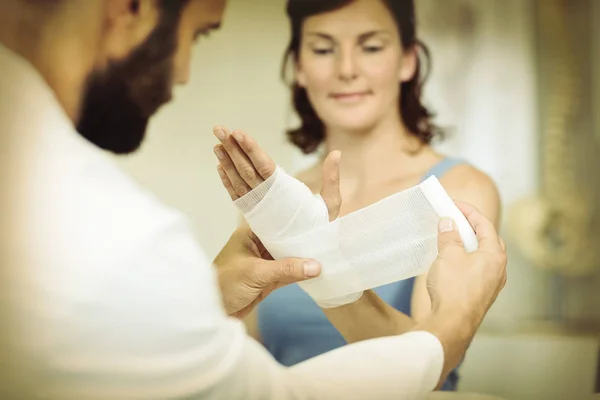 Φυσιοθεραπευτής Βάζοντας Επίδεσμο Χτυπημένο Του Χέρι Του Ασθενούς Στην Κλινική — Φωτογραφία Αρχείου