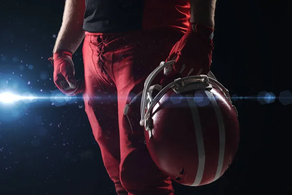 黒の背景にヘルメットと立っているアメリカン フットボール プレーヤーの中央部 — ストック写真