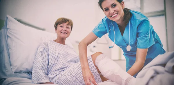 Retrato Enfermera Sonriente Vendando Pierna Del Paciente Hospital —  Fotos de Stock
