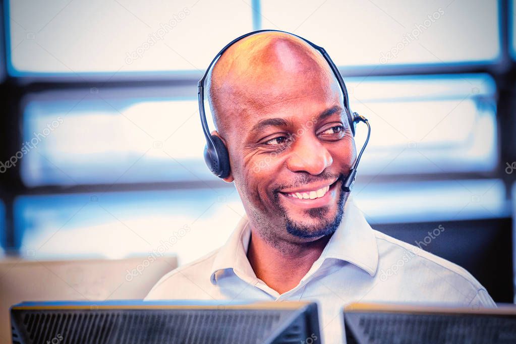 Man working on computer with headset in office