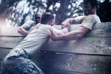 Asker adam boot Camp ahşap duvar tırmanmak için yardım