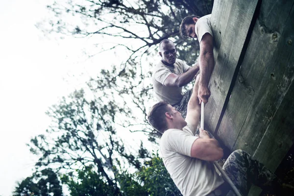 Soldados Ajudando Homem Subir Parede Madeira Acampamento Inicialização — Fotografia de Stock