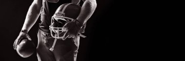 Orta bölümü ile kask ve rugby topu ayakta Amerikan futbolu oyuncusu