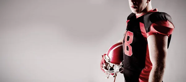 American Football Spieler Steht Mit Helm Vor Grauem Hintergrund — Stockfoto