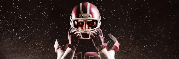 ラグビー ヘルメットと立っているアメリカン フットボール プレーヤーに対して粉の生成されたデジタル画像 — ストック写真