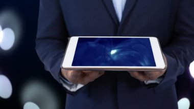 Tablet bilgisayar mavi tasarım animasyon ile ekran üzerinde tutan bir iş adamı. Parlayan bokeh arka planda ışıklar