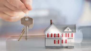 Yeni ev satın alma gösterilen kavramsal dijital animasyon. Yargıçlar anahtarları tutan el vurarak gavel ve model ev