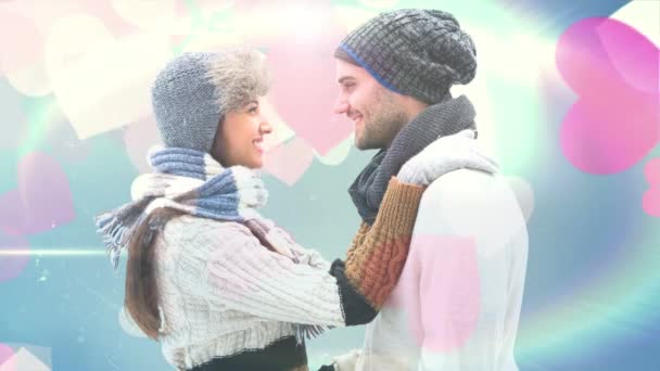 背景に浮かぶ大きなピンクの心でお互いを見て冬の服を身に着けているカップル — ストック動画