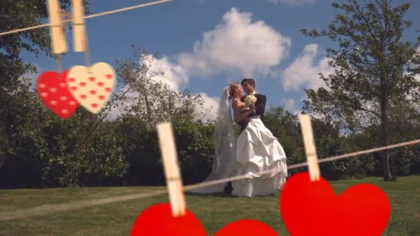 Happy Married Couple Kissing Parkland Flowers Bouquet Paper Hearts Hanging — Stock Video