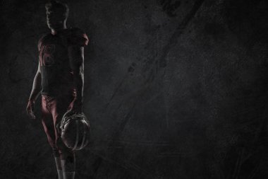 Rugby kask koyu gri arka planda tutan doğ