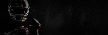 Tam kare fotoğrafını duvara karşı ragbi topu tutan kask içinde Amerikan futbolu oyuncusu