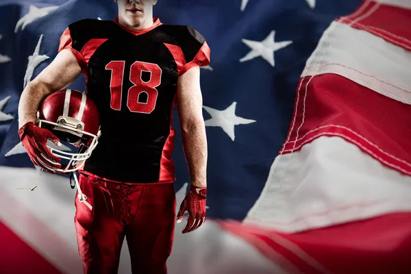 アメリカの国旗の完全なフレームに対してラグビー ヘルメットを保持しているバレーボール選手 — ストック写真