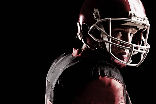 美国足球运动员的特写镜头在黑色背景下戴头盔 — 图库照片