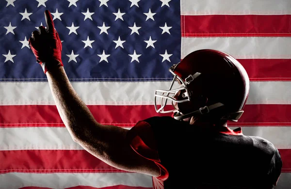 美国足球运动员在头盔指向向上对美国国旗与星星和条纹 — 图库照片