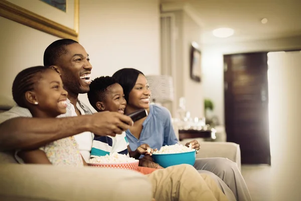 Iloinen Perhe Ottaa Popcornia Katsoessaan Televisiota Kotona — kuvapankkivalokuva