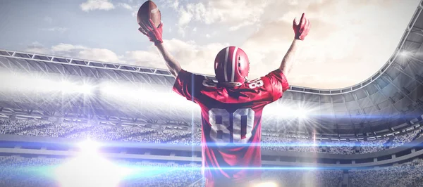 美国足球运动员戴头盔拿着橄榄球 双臂在空中对抗竞技场运动对多云天空的综合形象 — 图库照片