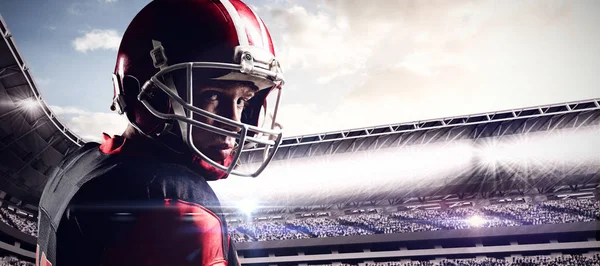 曇り空で満員のスタジアムに対するヘルメットに立っているアメリカン フットボール プレーヤー — ストック写真