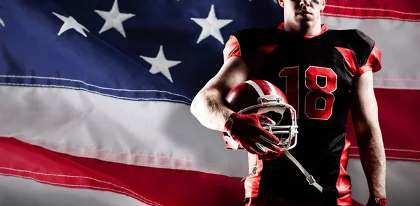美国足球运动员带着头盔站在美国国旗的特写镜头 — 图库照片