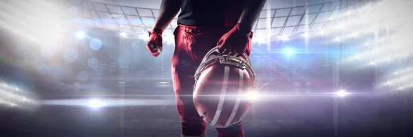 アメリカン フットボール アリーナに対してラグビー ヘルメットを保持しているバレーボール選手 — ストック写真