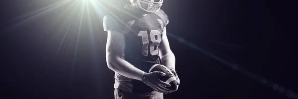 聚光灯对戴头盔的美国足球运动员 — 图库照片