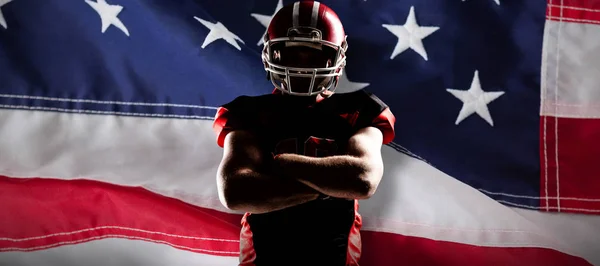 美国足球运动员站在双臂交叉对特写镜头的美国国旗 — 图库照片