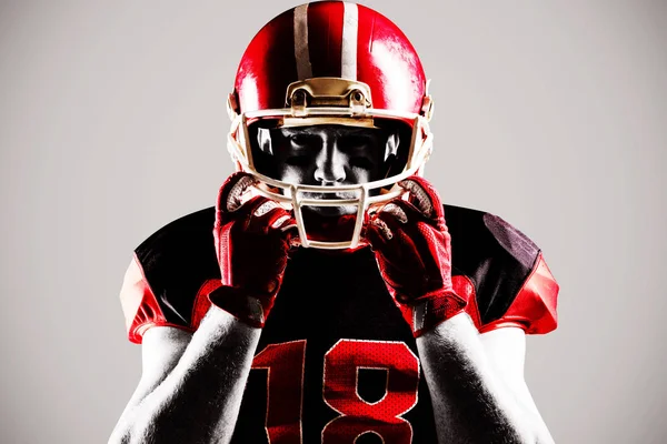 年轻的美国足球运动员戴着橄榄球头盔站着 — 图库照片
