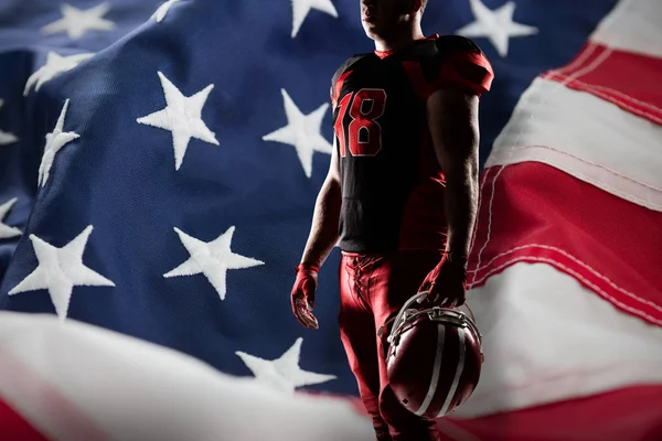 アメリカの国旗の完全なフレームに対してラグビー ヘルメットを保持しているバレーボール選手 — ストック写真