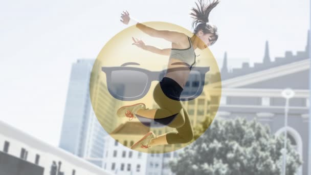 デジタル合成の背景をジャンプ フィット女性のデジタル構成に対してサングラスとアニメーションの黄色いスマイルの絵文字 — ストック動画