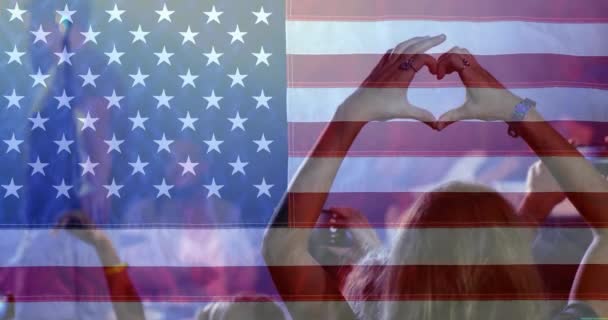 数字复合的妇女享受音乐会与手形成心脏在美国旗子背景 — 图库视频影像