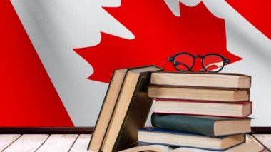 kitap ve gözlük ahşap masa üzerinde animasyonlu Kanada bayrağı çerçevede okul malzemeleri