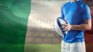 Dijital bileşkesi rugby topu tutarak ve rüzgarda sallayarak İtalyan bayrağı ile tam Stadı önünde ayakta rugby oyuncusu