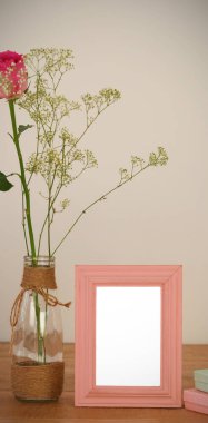 Gül çiçek cam vazo içinde bir tablo üzerinde fotoğraf çerçevesi ve hediye kutuları boş