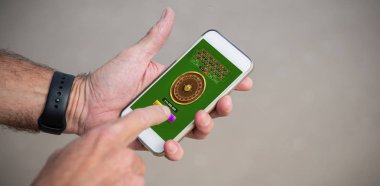 Telefonu kullanan adam kırpılmış görüntü karşı online rulet oyunu
