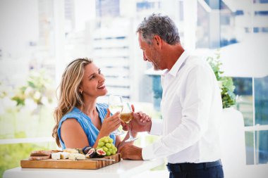 Olgun çift beyaz şarap restoranda toasting gülümseyen