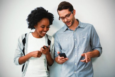 Beyaz duvara karşı duran ve cep telefonu kullanma office kadın ve erkek