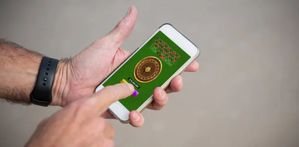 男の携帯電話を使用してのトリミングされたイメージに対してオンライン ルーレット ゲーム — ストック写真