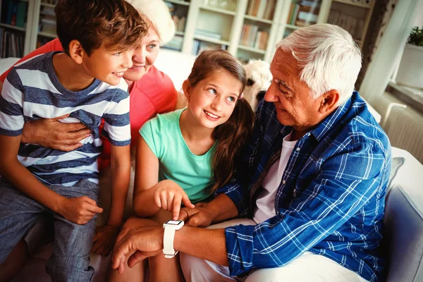 Großeltern Und Enkel Schauen Heimischen Wohnzimmer Auf Die Smartwatch — Stockfoto