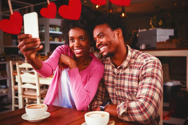 Harten Opknoping Een Lijn Tegen Gelukkige Jonge Paar Nemen Selfie — Stockfoto