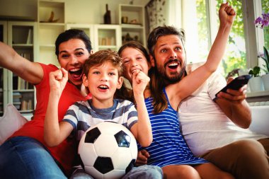 Excited family watching football match at home clipart