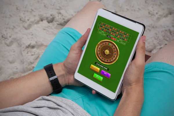 ビーチでデジタル タブレットを使用している人に対してオンライン ルーレット ゲーム — ストック写真
