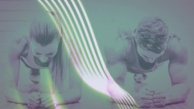 Spor salonunda spor yapan sağlıklı erkek ve kadının ön görüntüsü yeşil, parıldayan dijital çizgilere karşı.
