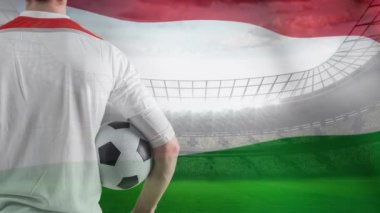 Macaristan Stadyumu çerçevede bir rüzgarda sallayarak bayrak önünde topu tutan futbolcu