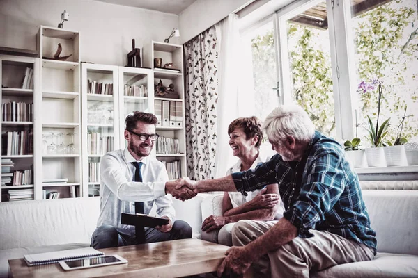 Conselheiro Financeiro Apertando Mãos Com Homem Mais Velho Sala Estar — Fotografia de Stock