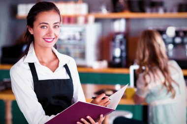 Gülümseyen garson kafede bir dosyada yazma portresi