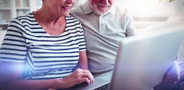 Üst düzey çift evde oturma odasında dizüstü bilgisayar kullanarak