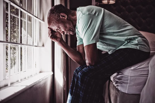 Zijaanzicht Van Ernstige Senior Man Zittend Bed Door Raam Thuis — Stockfoto